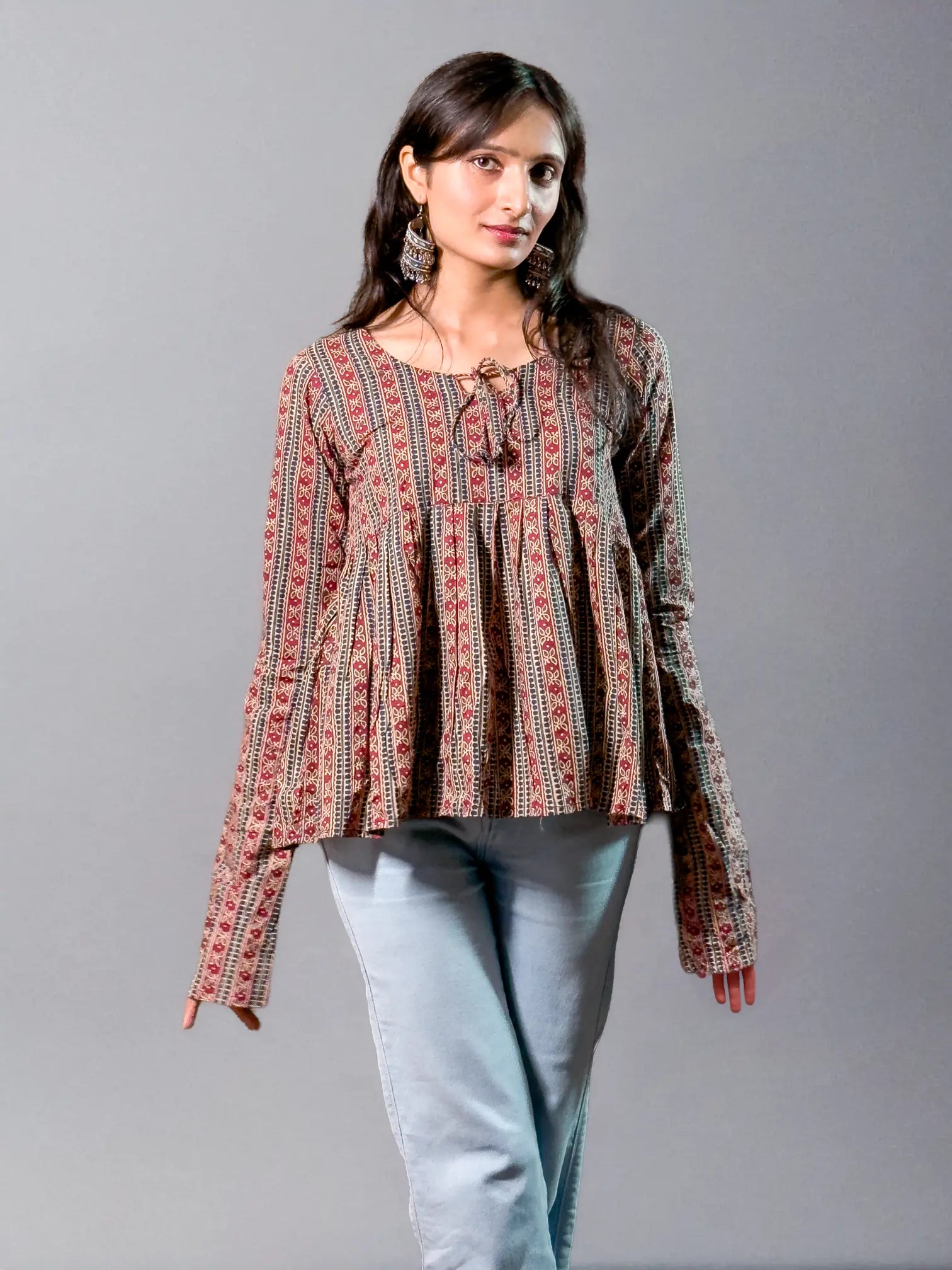 Woman wearing a patterned blouse with a neutral background
